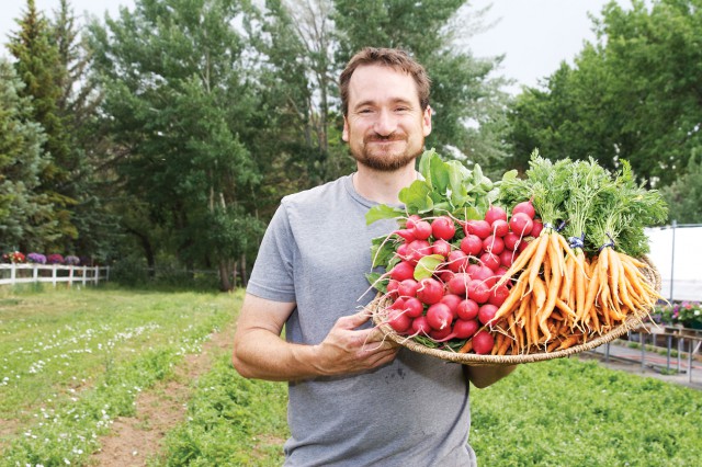 farmer Mark Guttridge with basket of carrots and radishes