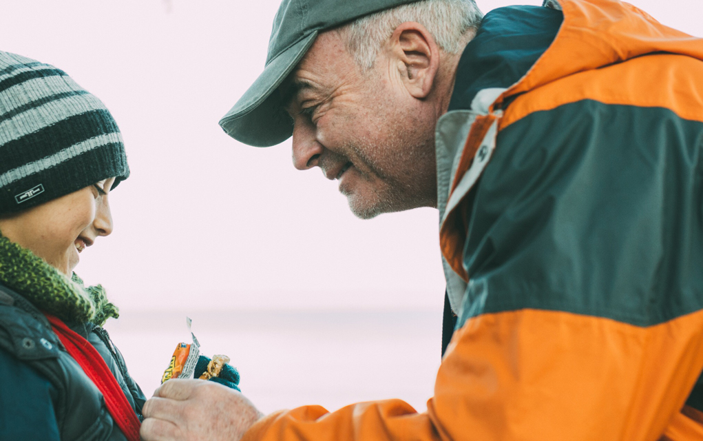 A volunteer with the International Medical Relief team makes a young refugee boy smile. 