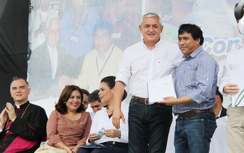 Juan with then president of Guatemala, Otto Pérez Molina, in 2014, at a ceremony officially implementing the reparations plan. 