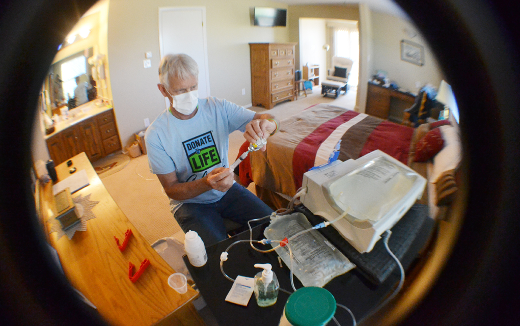 Jim Eastman prepares for his nightly dialysis treatment in his bedroom. 