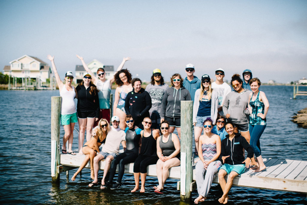 Amy Mossberg (bottom left) sits with a First Descents group on a pier in the Outer Banks of North Carolina.