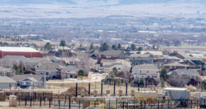 Hold on to your hats, it seems good government is possible fracking oil and gas well fenced in suburban neighborhood with trees and mountains in the background. Erie Colorado