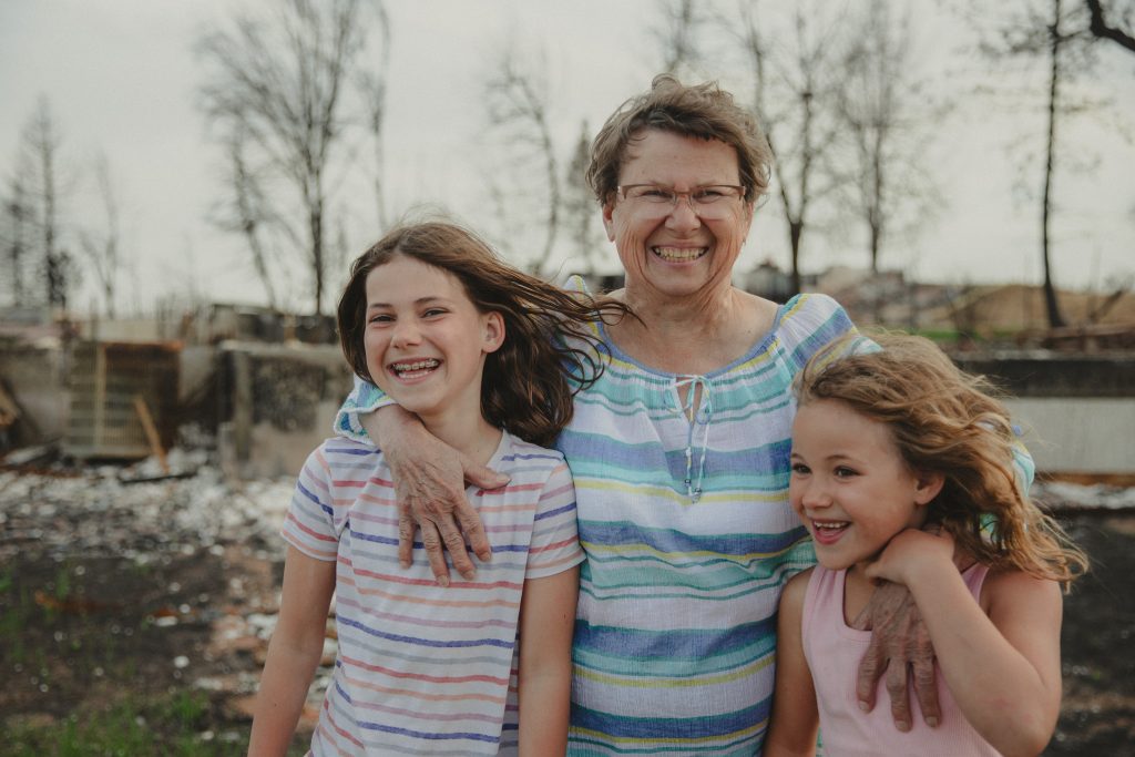 The Szucs family in front of their destroyed home as a result of the Marshall Fire.